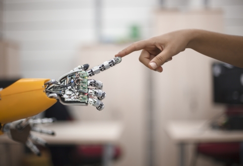 a human hand and an aritificial hand touching