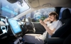 a woman is looking at a phone and using a self-driving car.